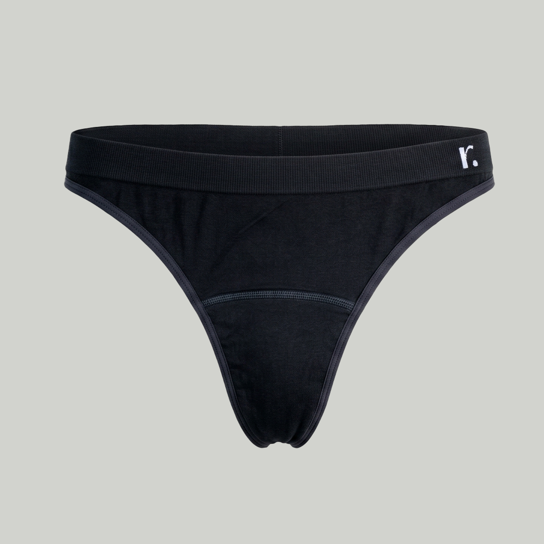 Front view of the black Rudie Period Thong on a plain pale background.